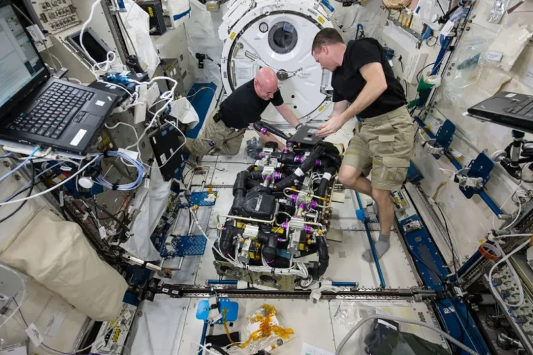 In this image, NASA astronauts Scott Kelly (left) and Terry Virts (right) work on a Carbon Dioxide Removal Assembly (CDRA) inside the station's Japanese Experiment Module. The CDRA system works to remove carbon dioxide from the cabin air, allowing for an environmentally safe crew cabin. Credit: NASA